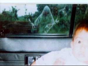 Foto de uma criança dentro de um carro e vultos aparecendo no vidro traseiro